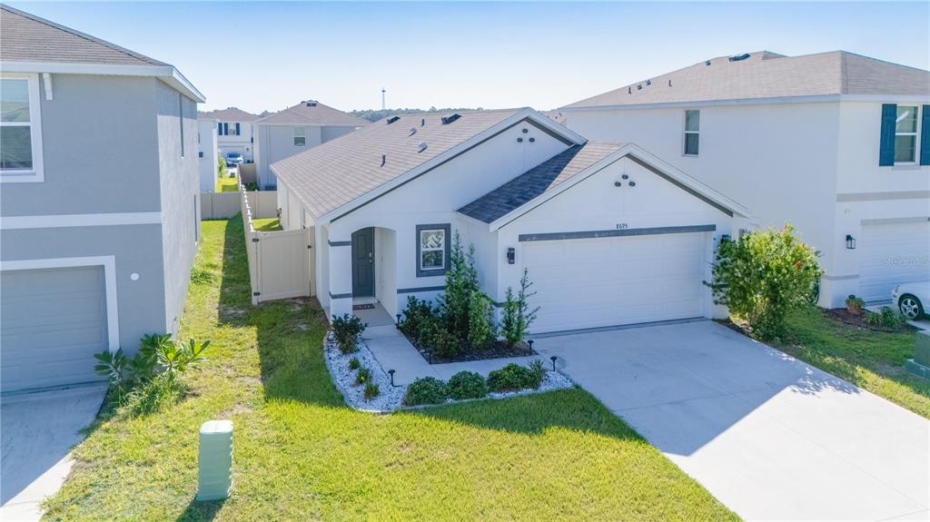 A single-story white house with a two-car garage and a small landscaped front yard — 8695 SW 46TH AVENUE, OCALA, FL