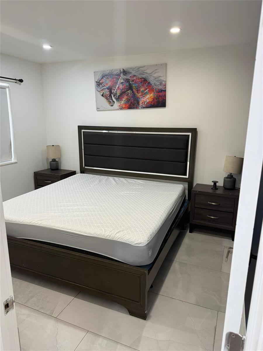 A bedroom features a dark wood bed frame, two matching nightstands, and a horse painting — 2201 Greene Street # 1, Hollywood FL 33020, HOLLYWOOD, FL