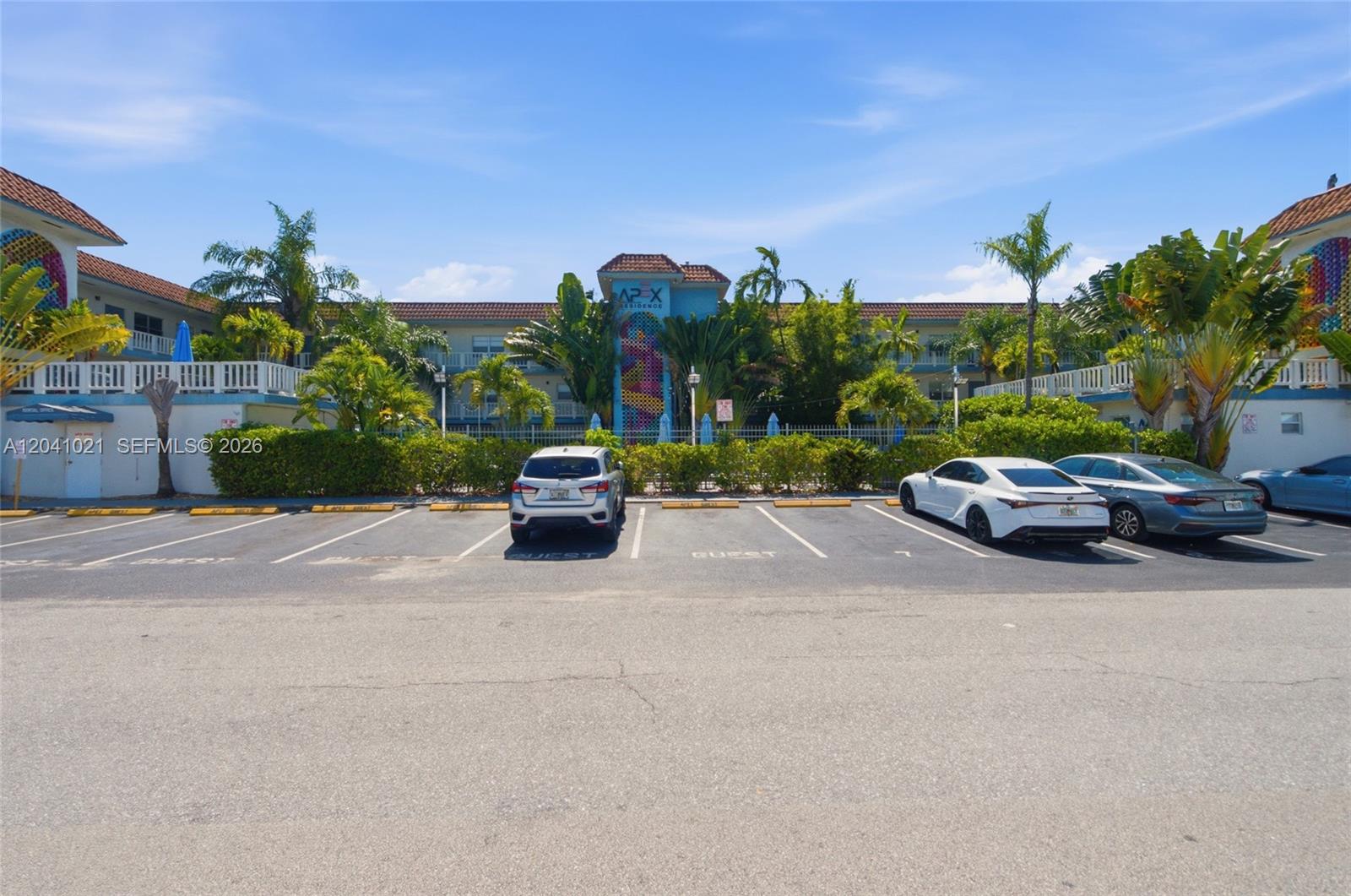 An exterior view of a multi-story apartment building with a parking lot in the foreground — FORT LAUDERDALE, FL
