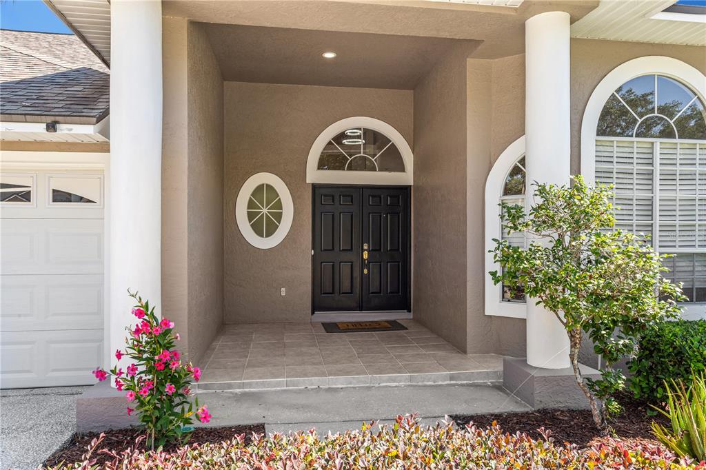 The exterior entrance features a double door, arched transom window, and two large white columns — 690 OAK HOLLOW WAY, ALTAMONTE SPRINGS, FL