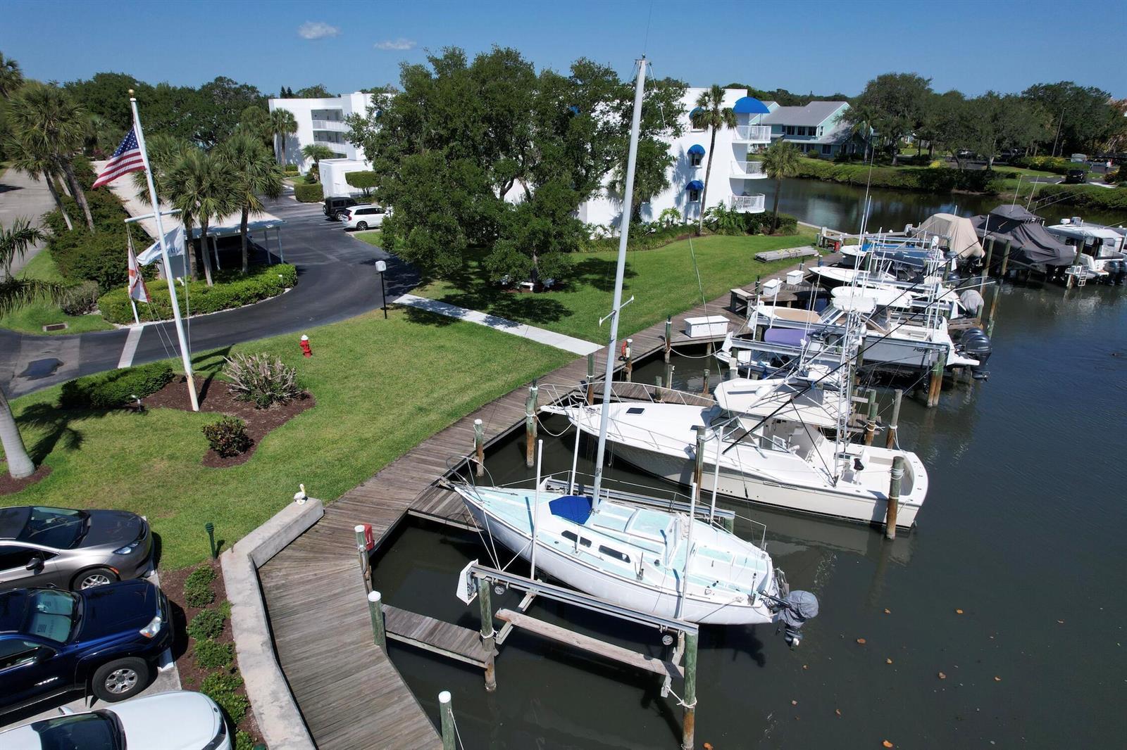 An aerial view shows a marina with several boats docked alongside a grassy parking area — SEBASTIAN, FL