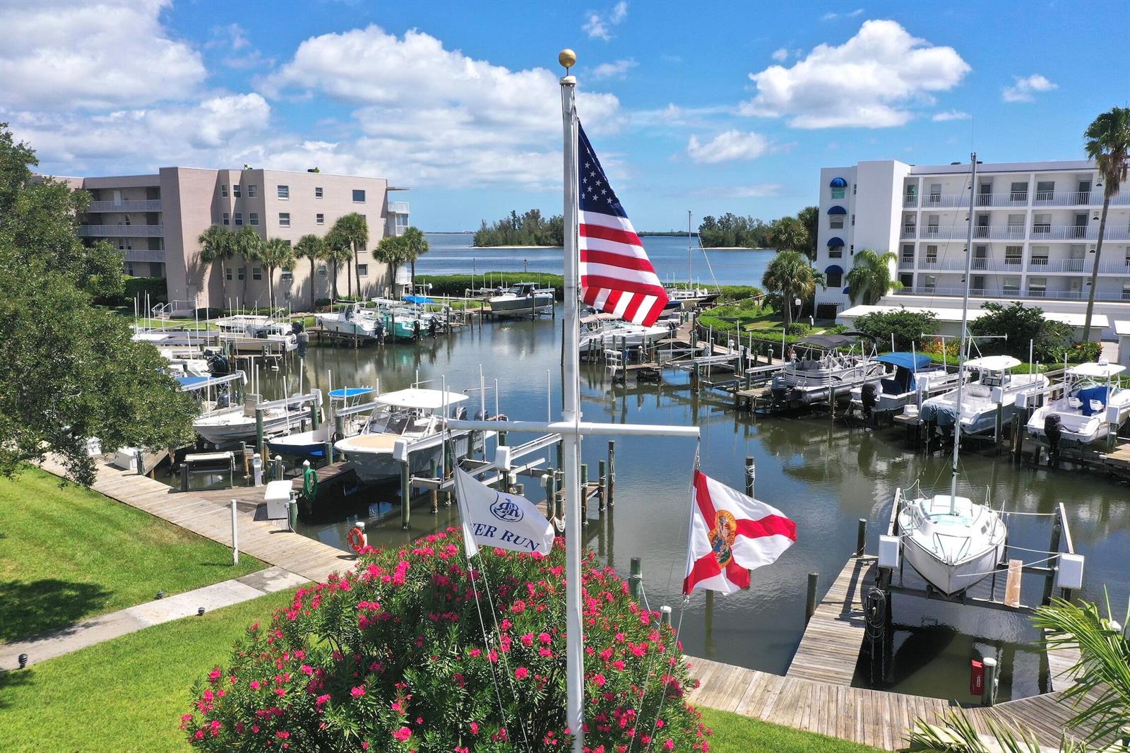 A view of a marina with multiple boats docked between two large apartment buildings — SEBASTIAN, FL