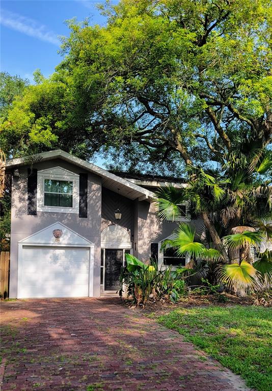 A two-story house with a brick driveway, a white garage door, and large shade trees — 814 LAUREL AVENUE UNIT 2, ORLANDO, FL