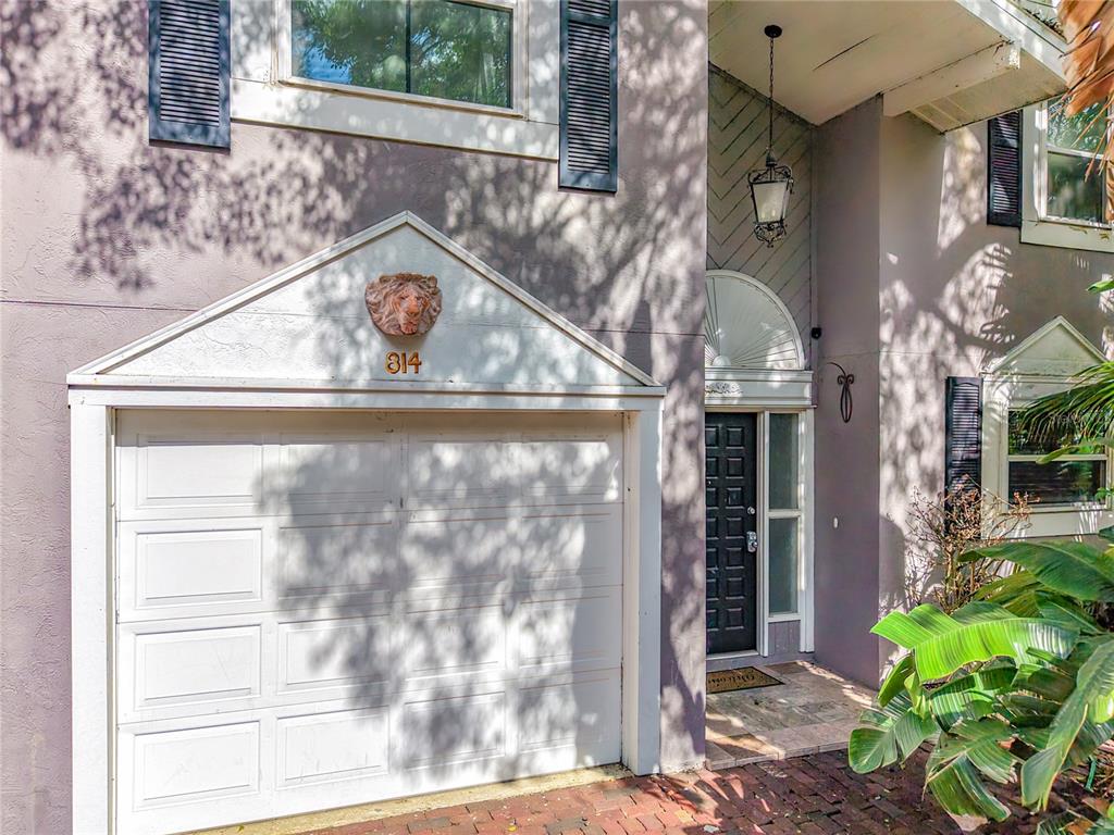 A two-story house exterior features a white garage door, a lion head emblem, and a front entrance — 814 LAUREL AVENUE UNIT 2, ORLANDO, FL