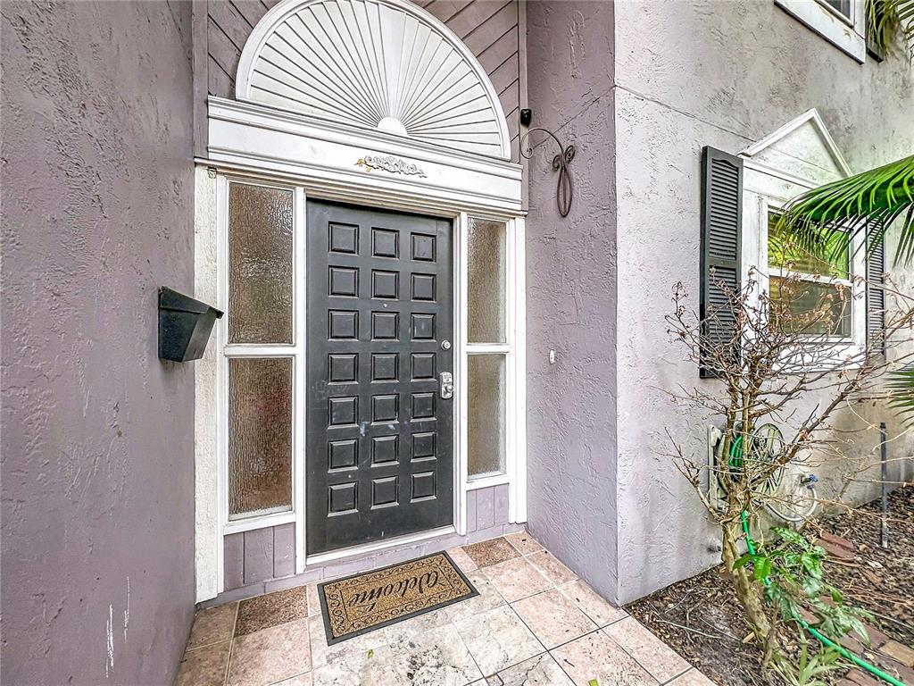 A black front door with sidelights and a decorative fanlight sits under a covered entryway — 814 LAUREL AVENUE UNIT 2, ORLANDO, FL