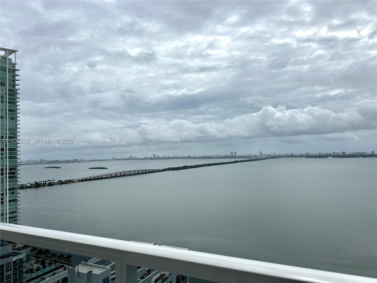 An elevated view of a bay with a long bridge under a cloudy sky — 600 NE 27th St # 2302, Miami FL 33137, MIAMI, FL
