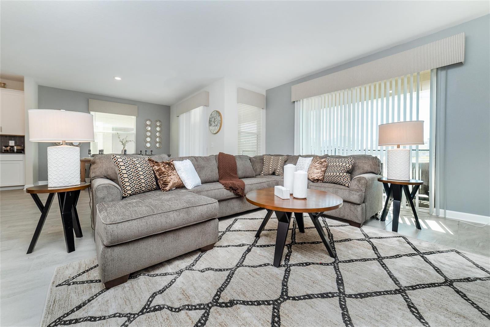 A living room features a gray sectional sofa, a round coffee table, and two lamps — 8936 Cabot Cliffs, Davenport FL 33896, DAVENPORT, FL