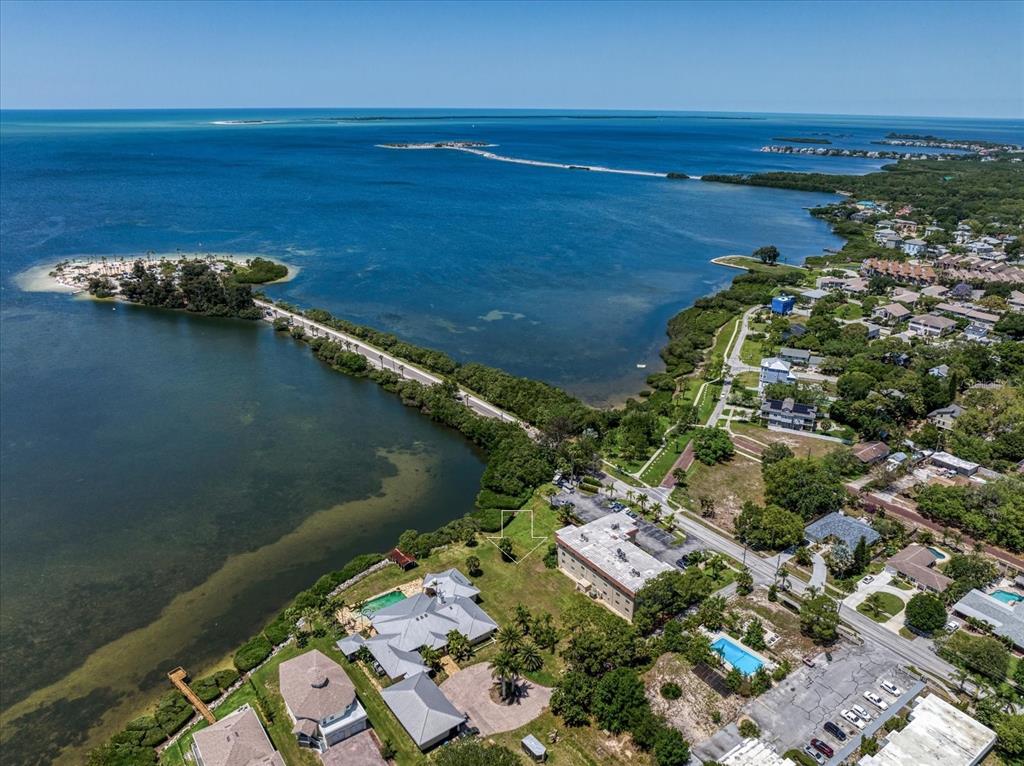 An aerial view shows a coastal property with a house, pool, and surrounding vegetation — 1725 GULF ROAD, TARPON SPRINGS, FL
