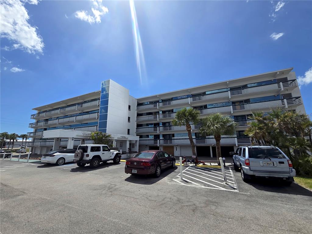 A multi-story commercial building with a parking lot and several parked vehicles in front — 1460 S MCCALL ROAD UNIT A2, ENGLEWOOD, FL