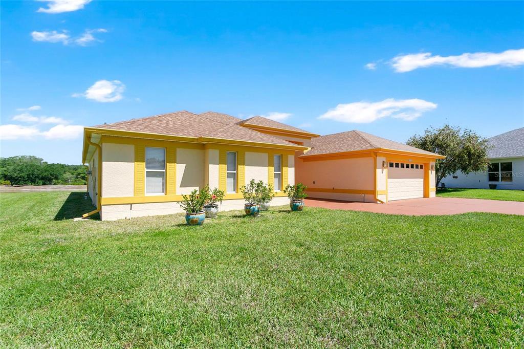 A single-story house with a tan exterior, yellow trim, and an attached two-car garage — 5712 SUMMERBROOKE COURT, LEESBURG, FL