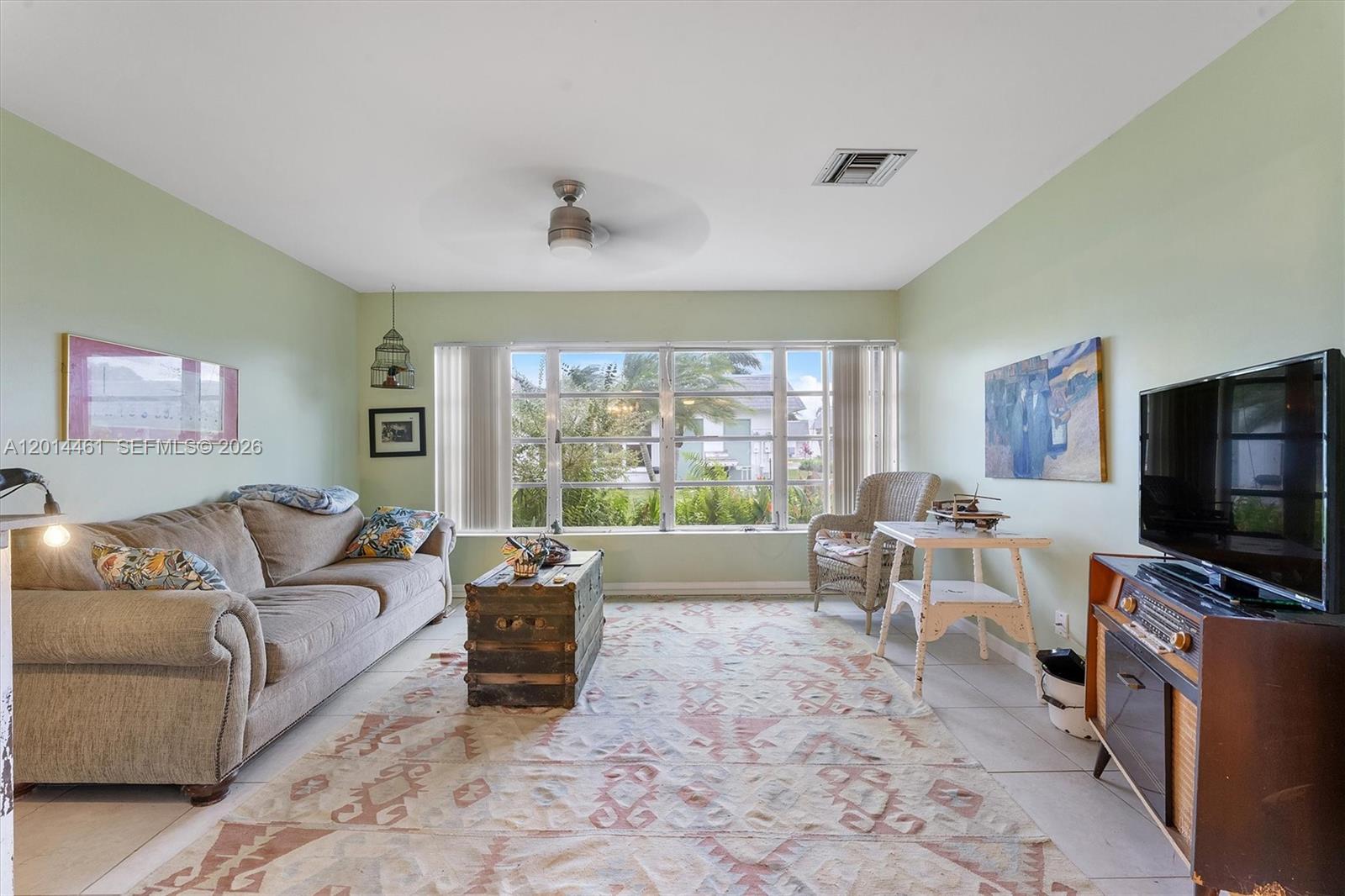 A living room features a beige sofa, a trunk coffee table, and a television console — 2638 E Gately Dr E # 85, West Palm Beach FL 33415, WEST PALM BEACH, FL