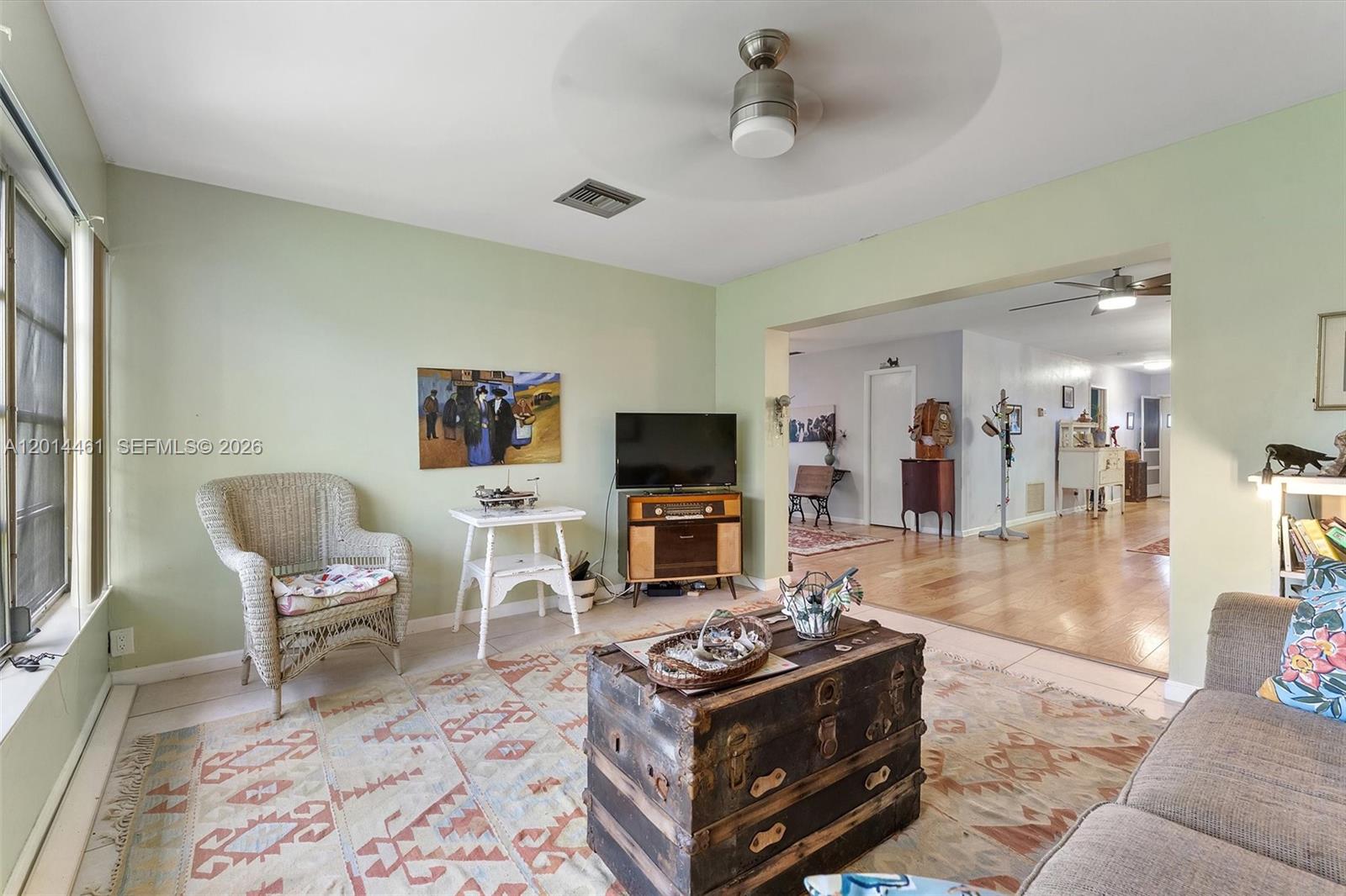 A living room features light green walls, a patterned rug, a trunk coffee table, and furniture — 2638 E Gately Dr E # 85, West Palm Beach FL 33415, WEST PALM BEACH, FL