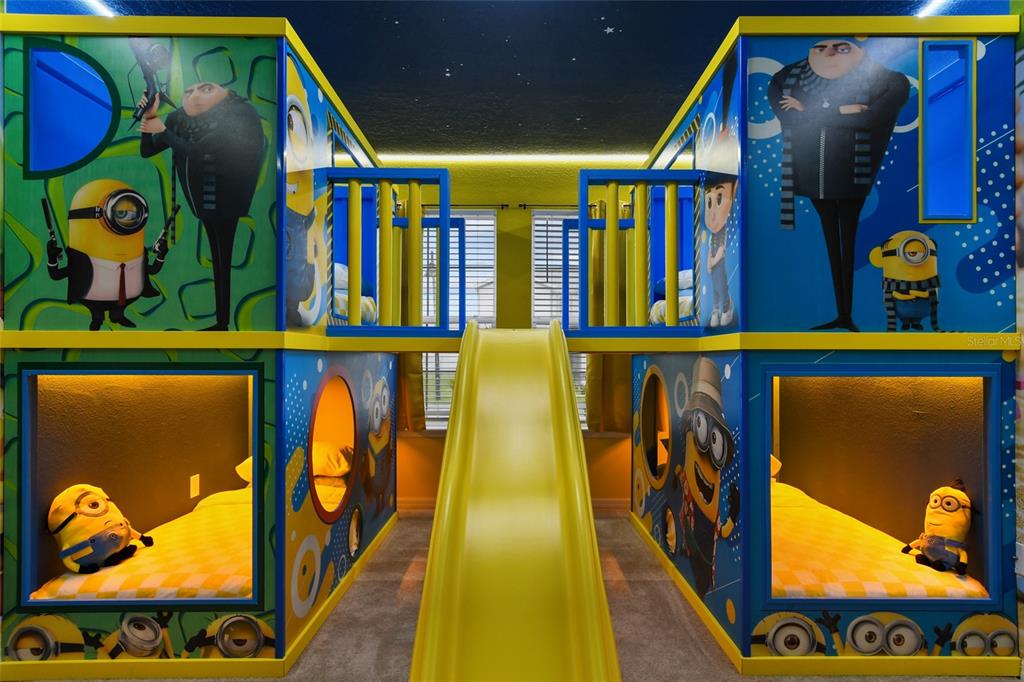 A themed bedroom features two bunk beds with a central yellow slide between them — 3740 LANA AVENUE, DAVENPORT, FL