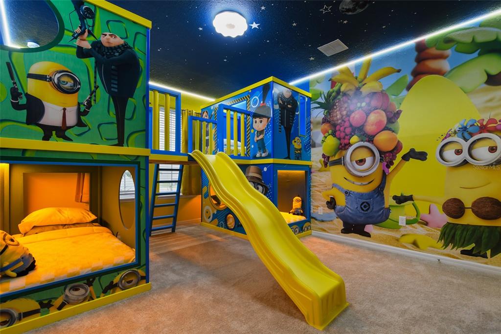 A themed bedroom features a yellow slide, bunk beds, and wall murals of Minion characters — 3740 LANA AVENUE, DAVENPORT, FL