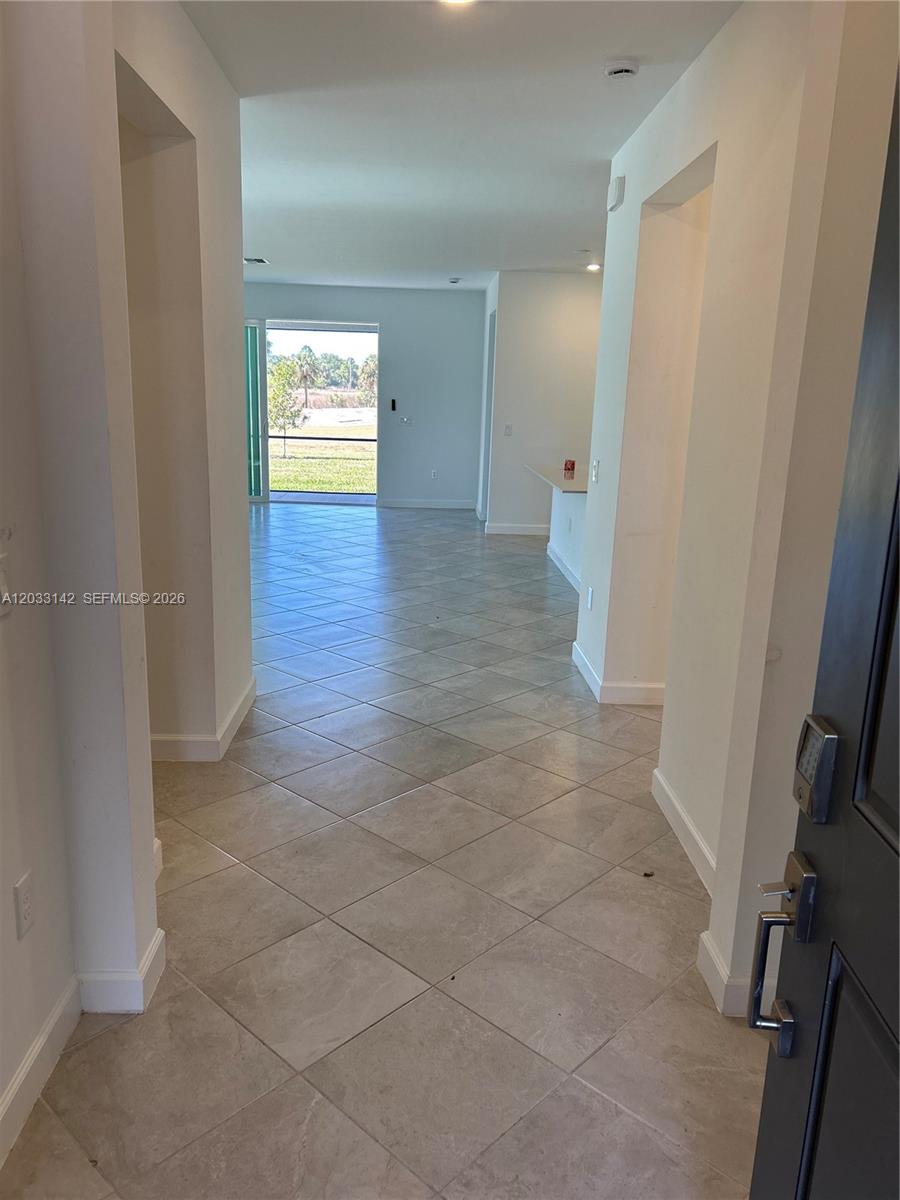 A tiled entryway leads into an open-concept living area with a view of the outdoors — 20483 Copperhead DR, Lehigh Acres FL 33936, LEHIGH ACRES, FL