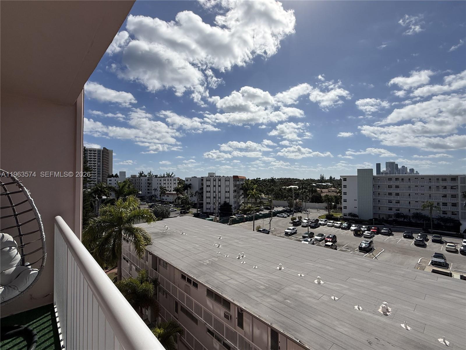 A high-angle view from a balcony overlooking a parking lot and surrounding apartment buildings — 3161 S Ocean Dr # 608, Hallandale Beach FL 33009, HALLANDALE BEACH, FL