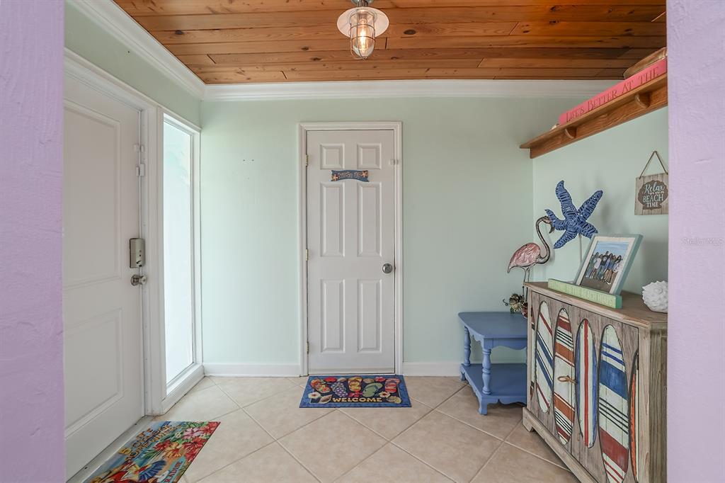 An entryway features light green walls, a wood-plank ceiling, tile flooring, and beach-themed decor — 270 BOYLSTON AVENUE, DAYTONA BEACH, FL