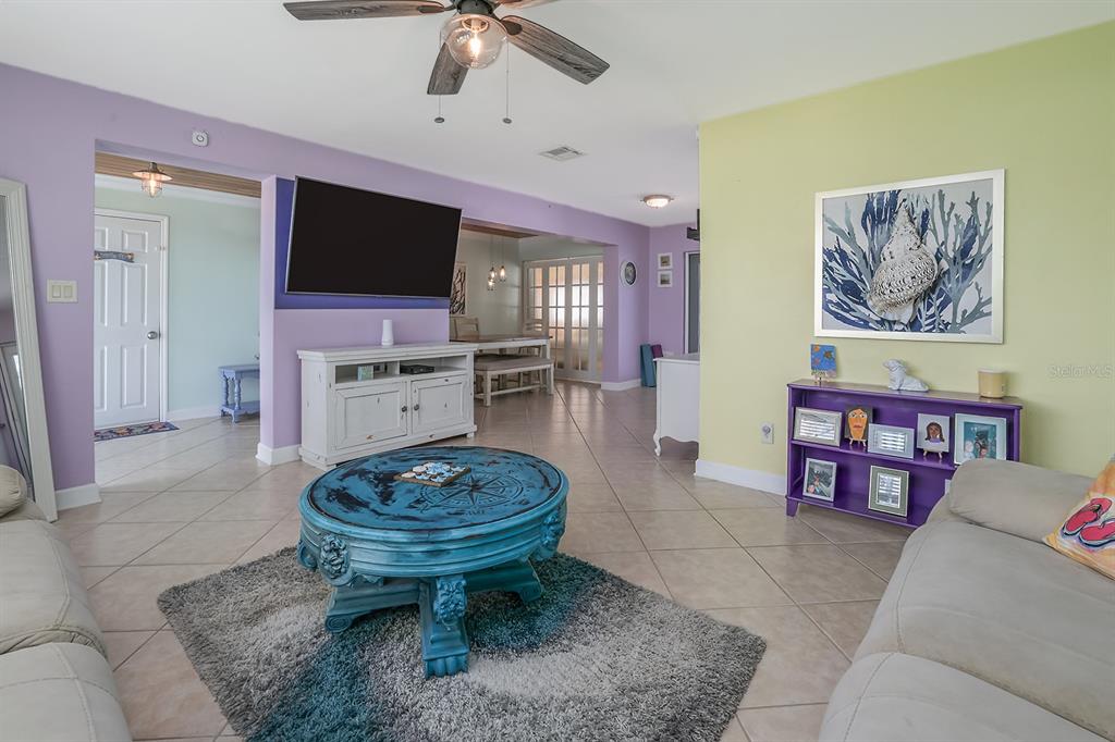 A living room features a blue coffee table, a purple console, and light-colored tile floors — 270 BOYLSTON AVENUE, DAYTONA BEACH, FL