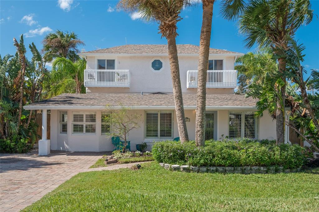 A two-story house with a white exterior, two upper balconies, and a paved driveway — 1422 N ATLANTIC AVENUE, NEW SMYRNA BEACH, FL