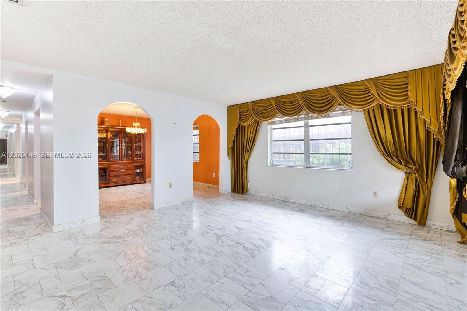 A living room features white marble floors, arched doorways, and heavy gold curtains over windows — 320 NW 61st Ave, Miami FL 33126, MIAMI, FL
