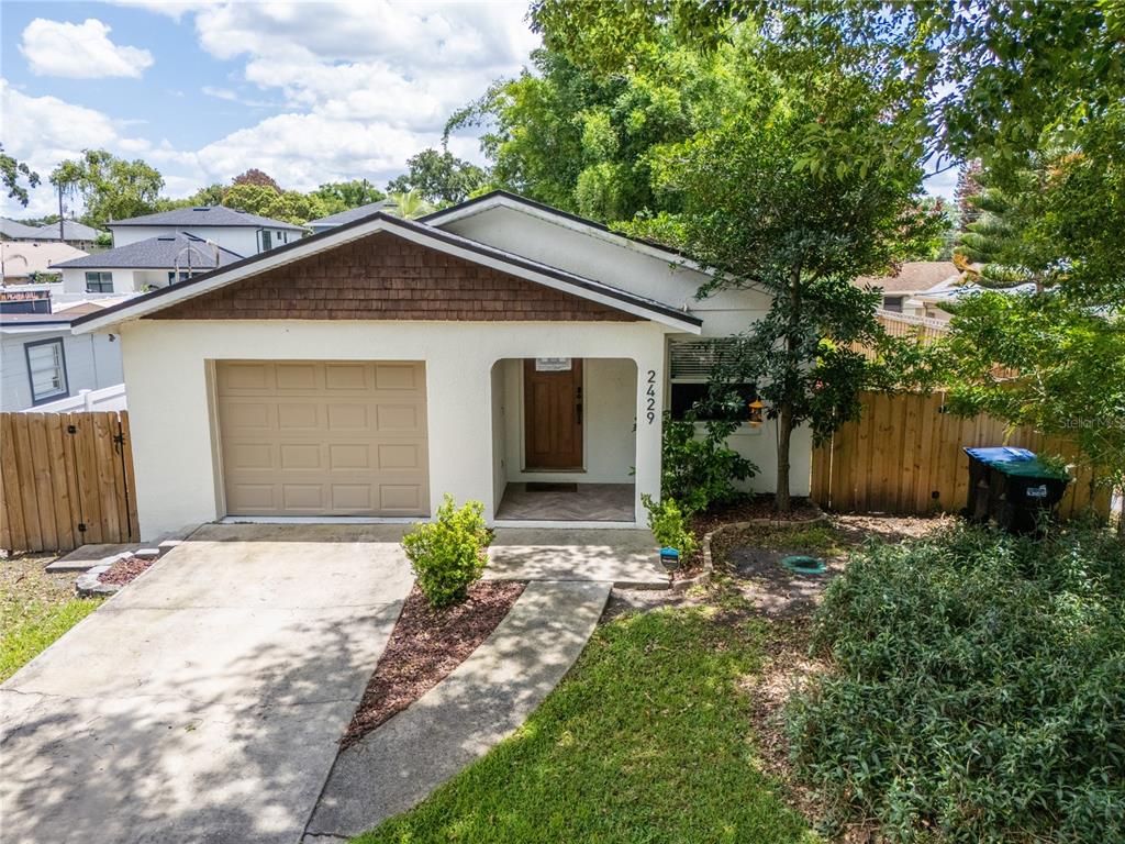 A single-story house with a tan garage, wood-shingled gable, and a covered front entryway — 2429 S BROWN AVENUE, ORLANDO, FL
