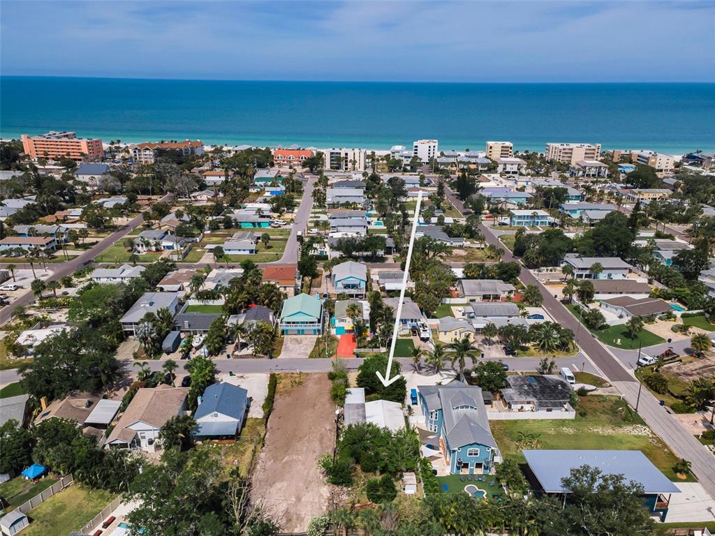 An aerial view shows a coastal neighborhood with a white arrow pointing to a house — 1213 BAY PALM BOULEVARD, INDIAN ROCKS BEACH, FL