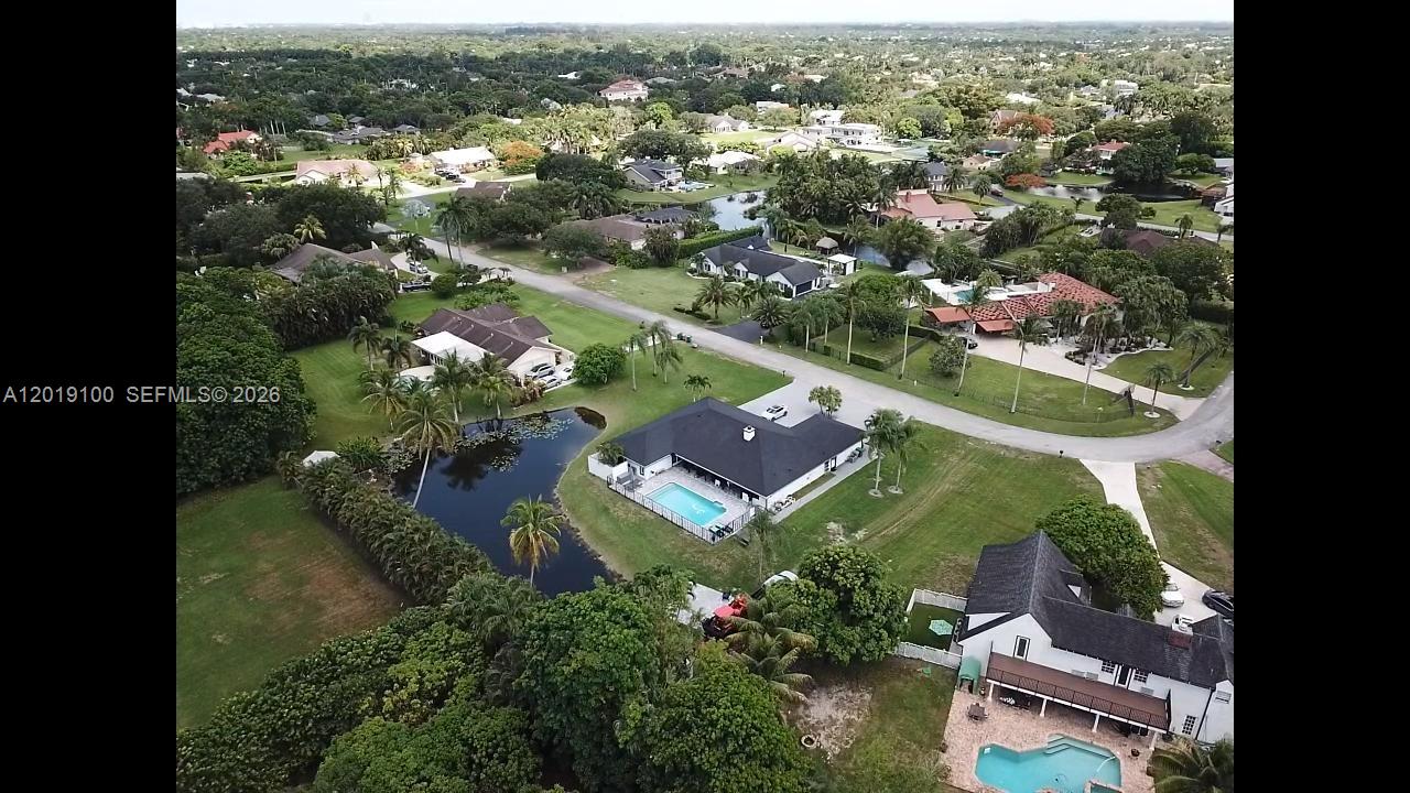 An aerial view shows several houses with swimming pools surrounded by trees and a pond — 11701 SW 21st Ct, Davie FL 33325, DAVIE, FL