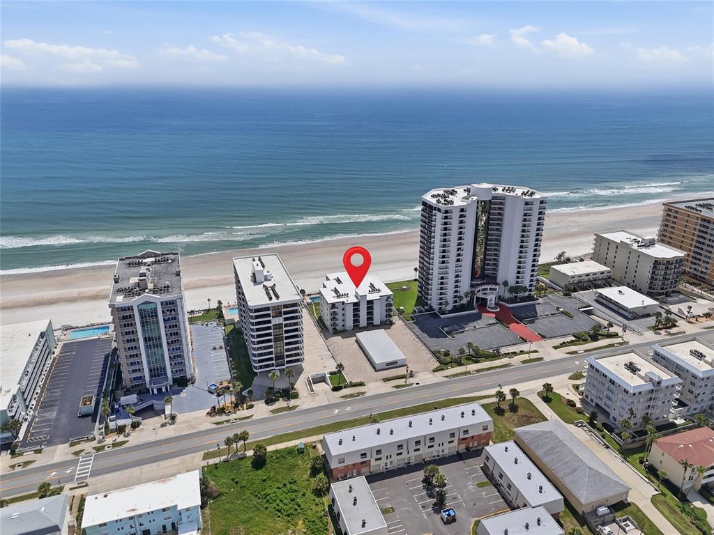 An aerial view shows several beachfront high-rise buildings along a sandy coastline — 3747 S ATLANTIC AVENUE UNIT 4050, DAYTONA BEACH, FL