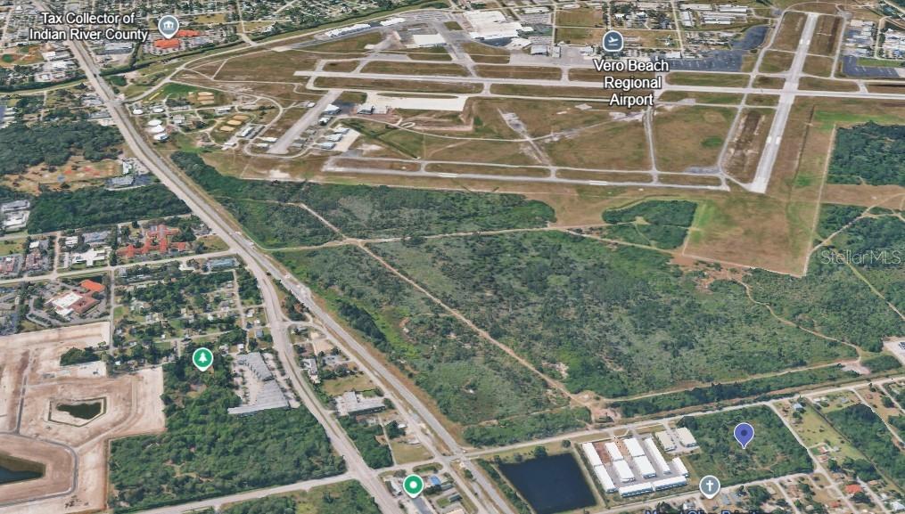 An aerial view shows a large, undeveloped plot of land adjacent to an airport — 2600 41ST STREET, VERO BEACH, FL