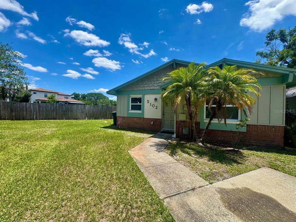 A single-story house with a brick and siding exterior features a front lawn and walkway — 5102 LAWNTON COURT, TAMPA, FL