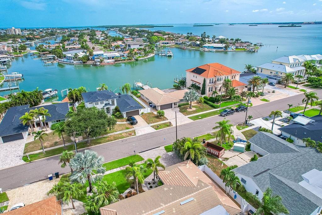 An aerial view of a waterfront residential neighborhood with houses, palm trees, and boat docks — 340 PALM ISLAND NE, CLEARWATER BEACH, FL
