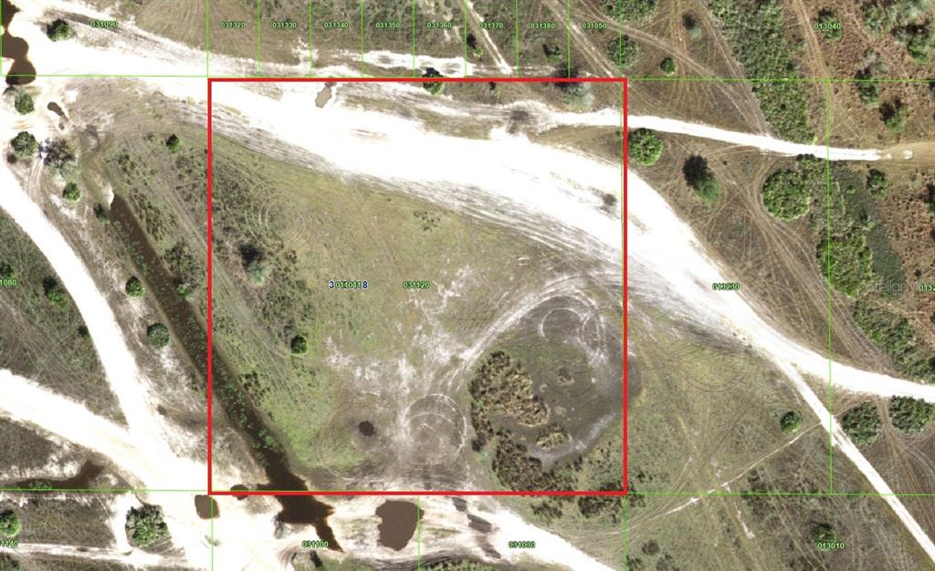 An aerial view of a vacant, rectangular plot of land outlined in red — HWY 630, FROSTPROOF, FL