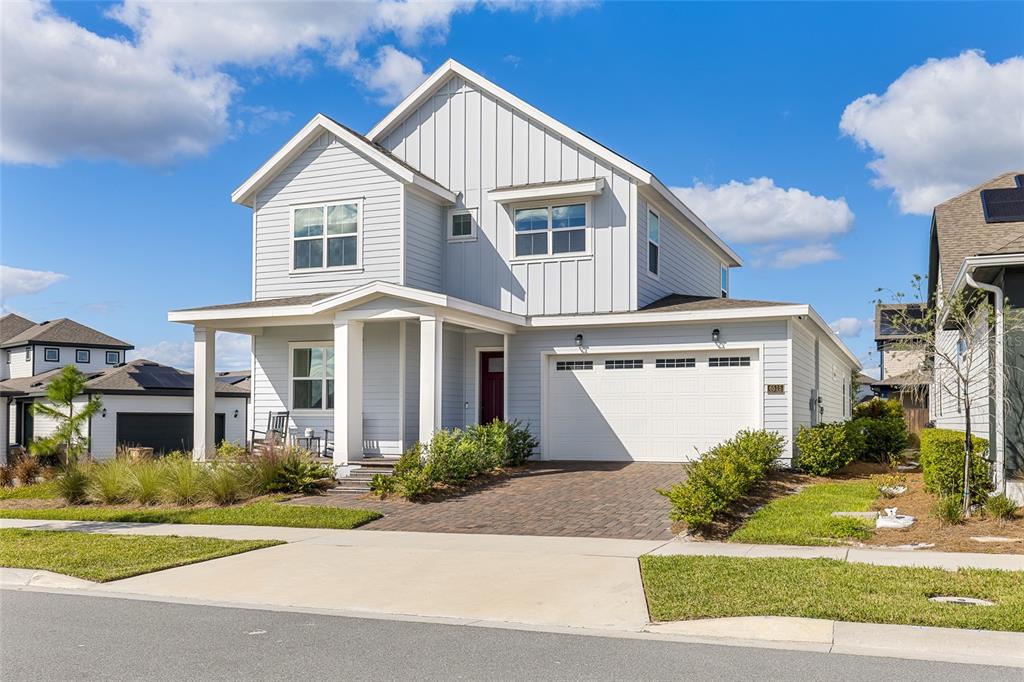 A two-story house with light gray siding, a front porch, and a two-car garage — 6515 QUEST STREET, ST CLOUD, FL