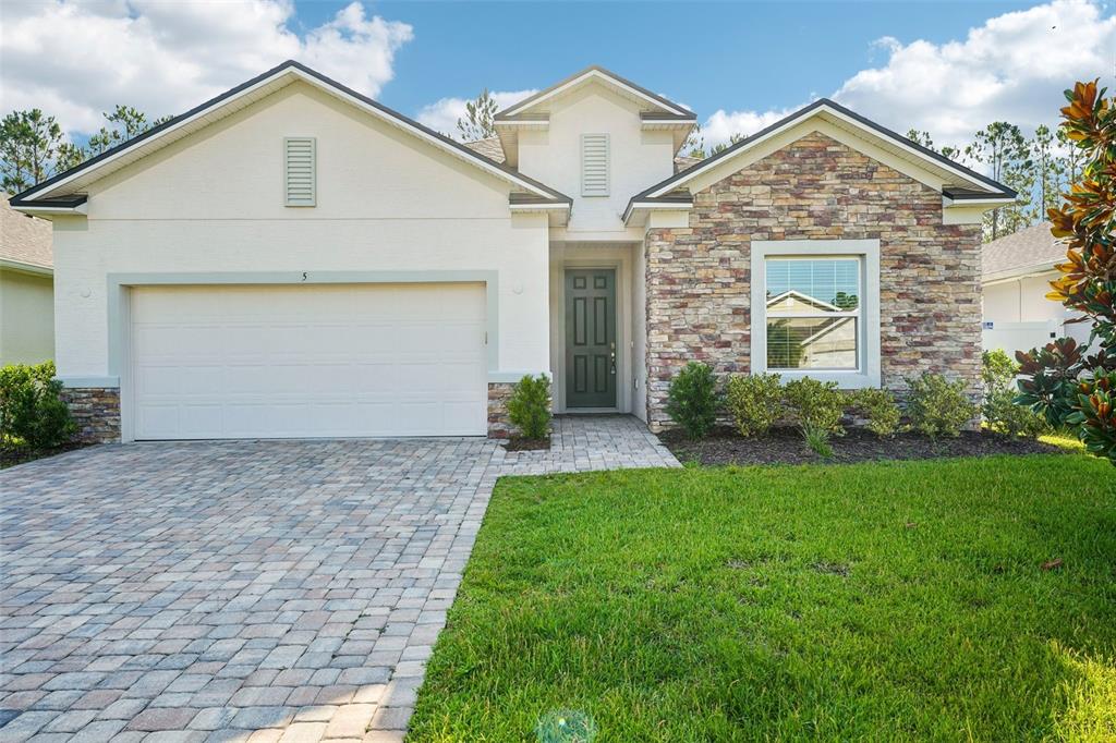 A single-story house with a stone facade, a two-car garage, and a paved driveway — 5 RIVERTOWN ROAD, PALM COAST, FL