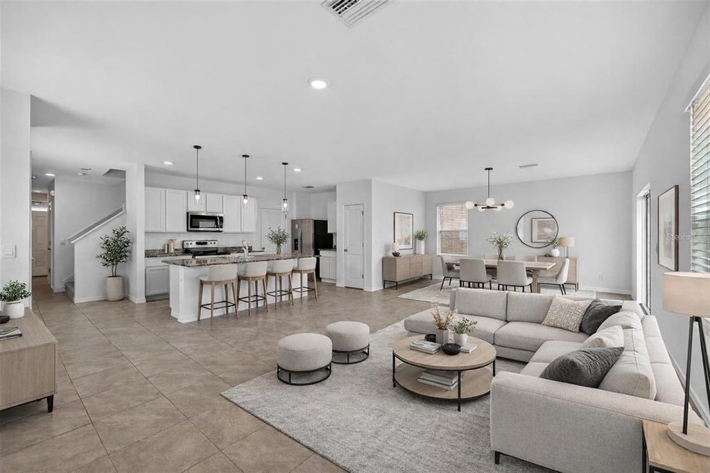 An open-concept living room, dining area, and kitchen with white cabinets and tile flooring — 3842 SUNNY SPRING STREET, PLANT CITY, FL