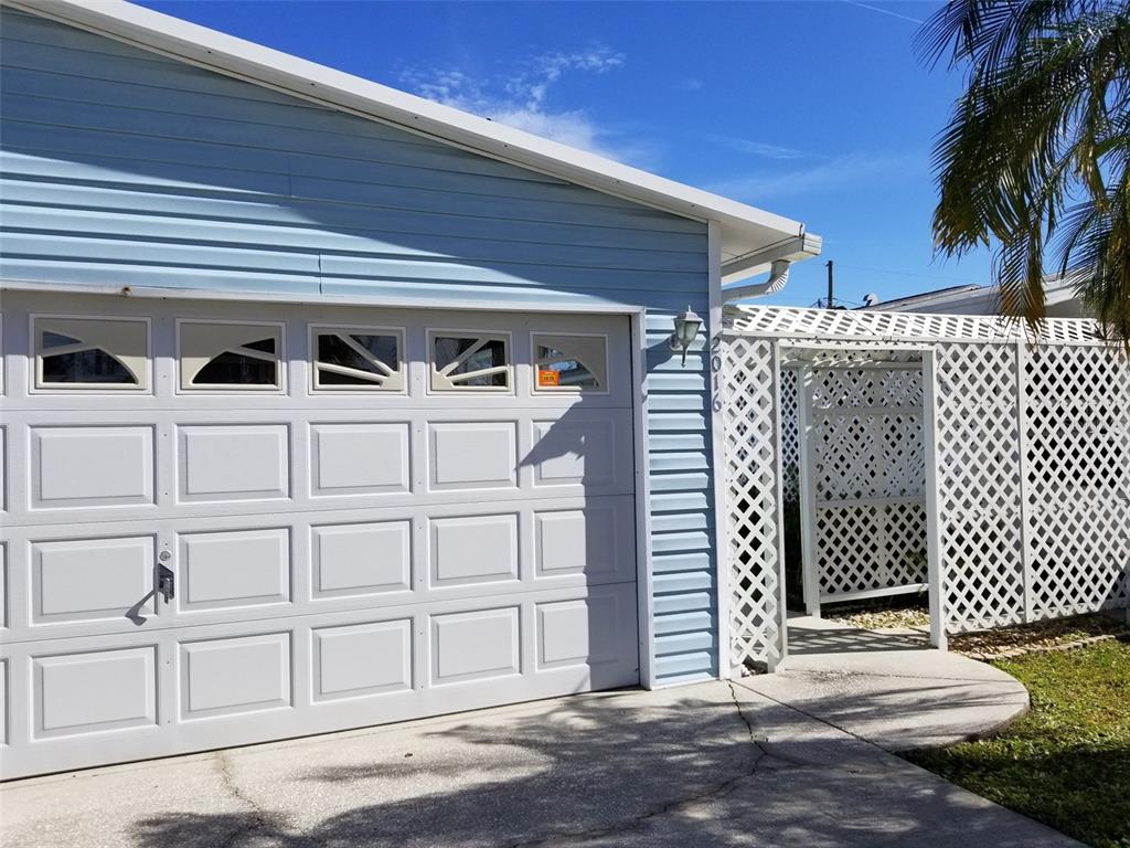 A light blue house features a white garage door and a white lattice privacy screen — 2016 LAKE LINDA CIRCLE, LUTZ, FL