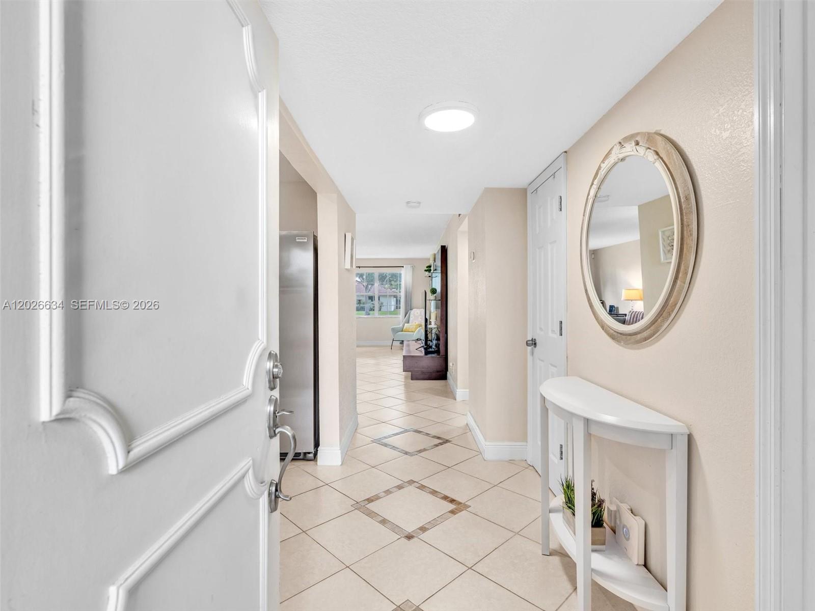 An entryway features a white console table, an oval mirror, and tile flooring — 3660 Citrus Trce # 2, Davie FL 33328, DAVIE, FL