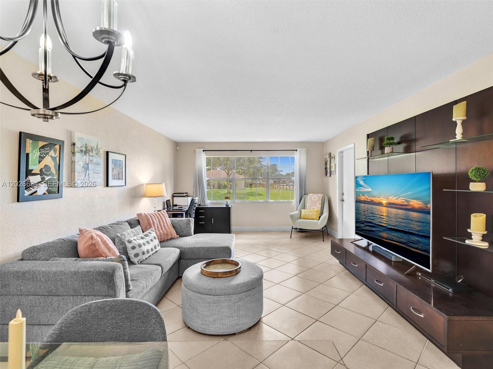 A living room features a gray sectional sofa, a television unit, and tile flooring — 3660 Citrus Trce # 2, Davie FL 33328, DAVIE, FL