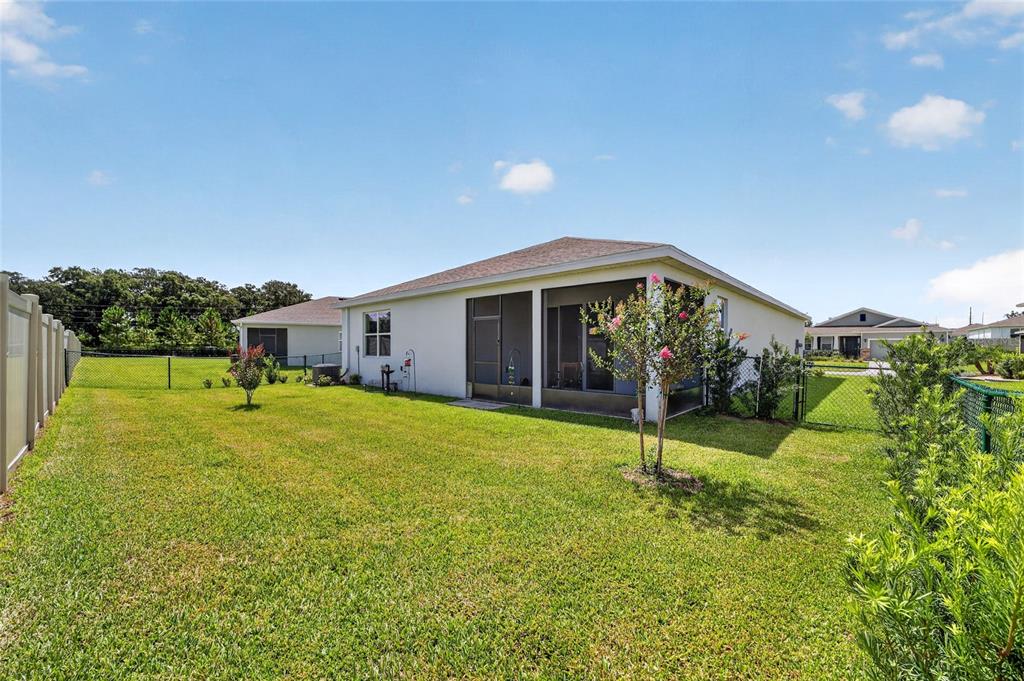 A backyard view of a house with a screened-in porch and a fenced lawn — 6083 SW 93RD LOOP, OCALA, FL