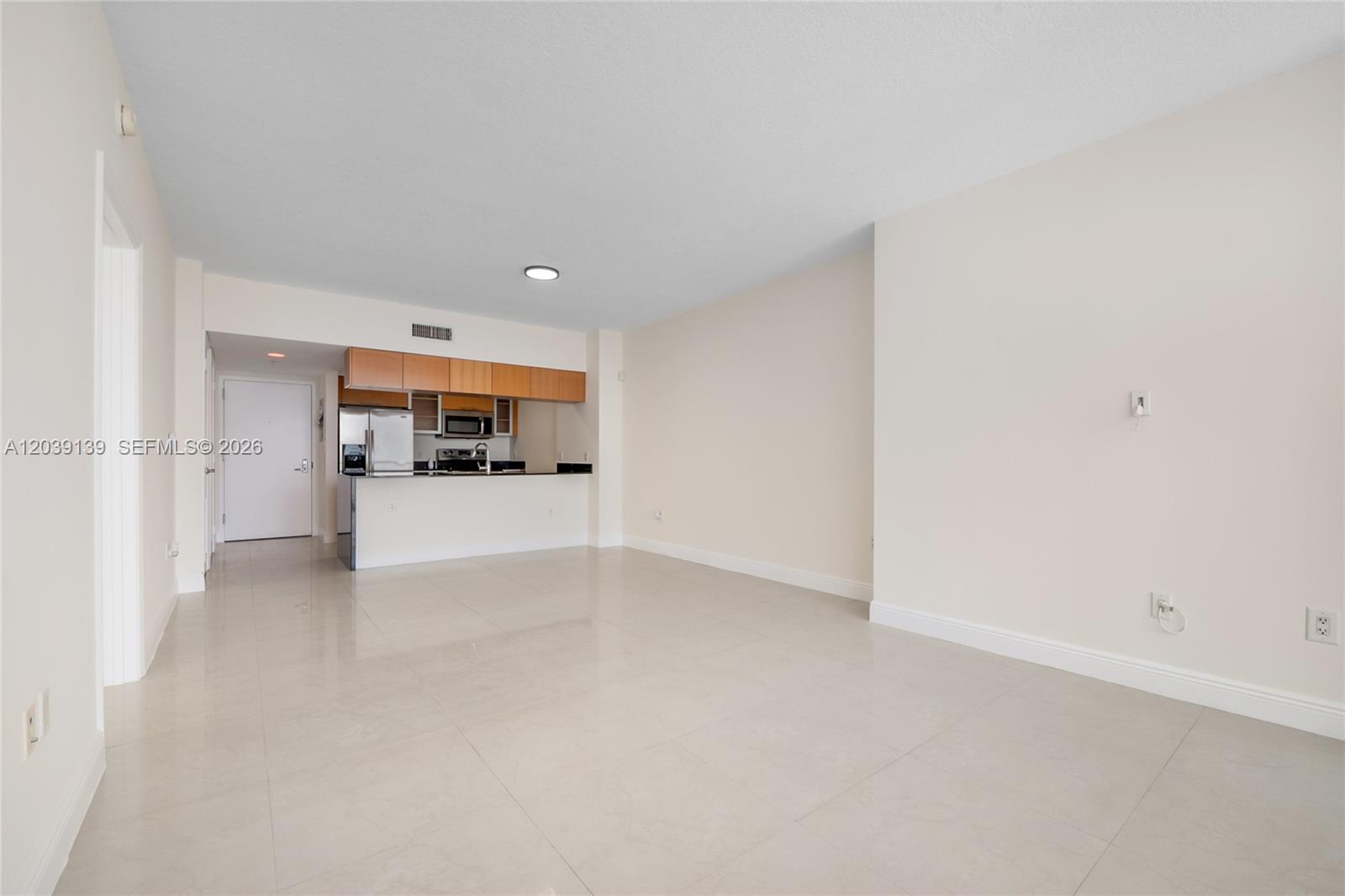 An open-concept living area features light tile flooring and a kitchen with wooden cabinets — 1750 N Bayshore Dr # 4811, Miami FL 33132, MIAMI, FL