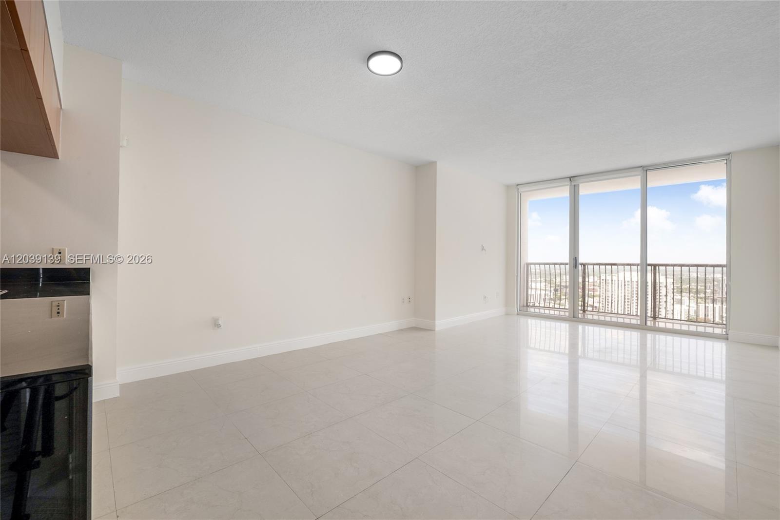 This bright, empty room features light-colored tile flooring, white walls, and a sliding glass balcony door — 1750 N Bayshore Dr # 4811, Miami FL 33132, MIAMI, FL