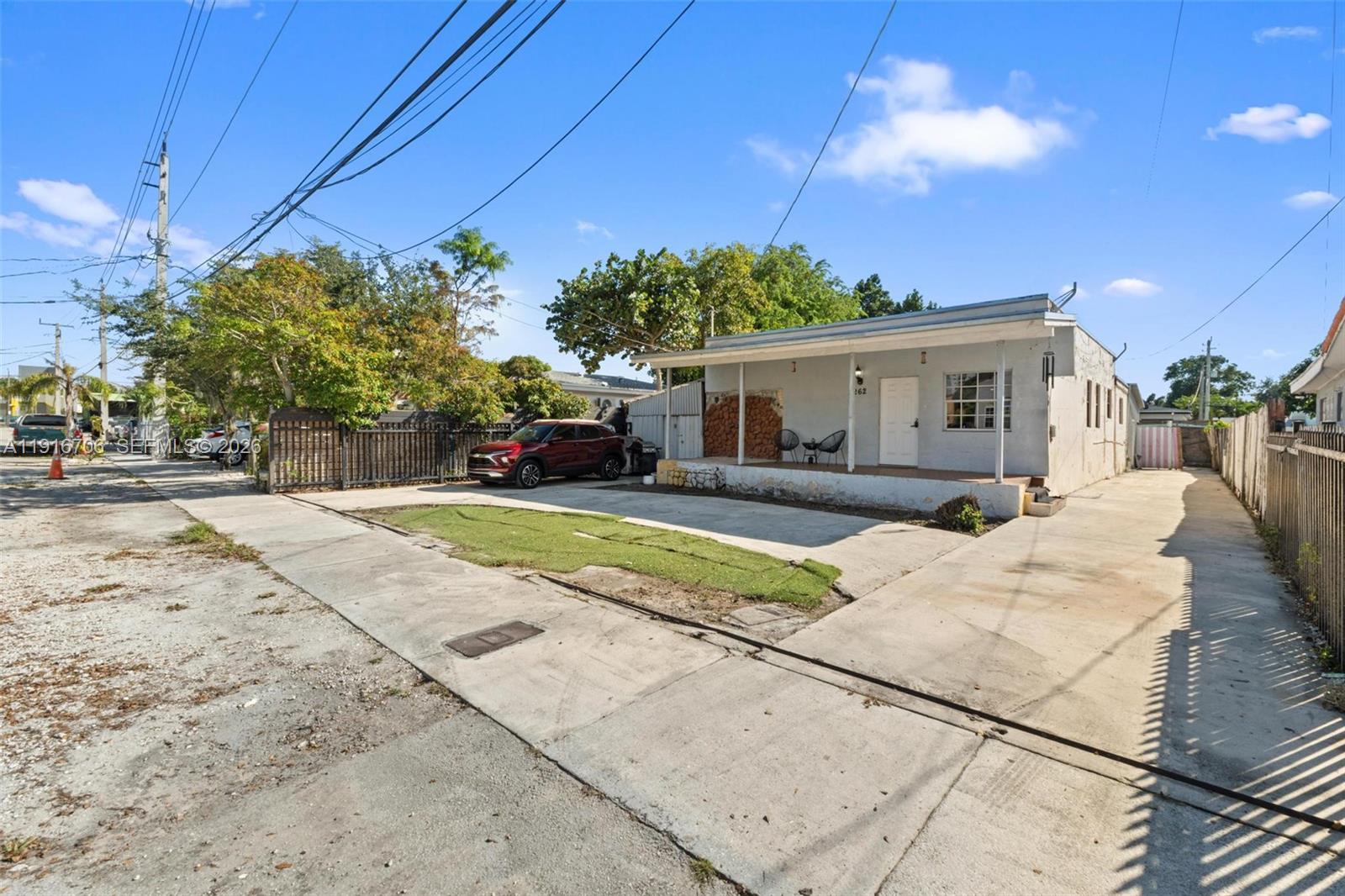 A single-story house with a concrete driveway and a small front porch under a blue sky — 2262 NW 4th St, Miami FL 33125, MIAMI, FL