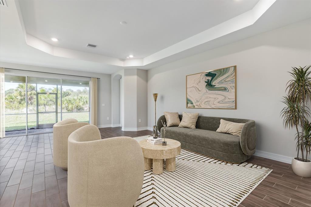 A living room features a curved sofa, two armchairs, a round coffee table, and sliding doors — 12718 SEAGRASS DRIVE, PUNTA GORDA, FL