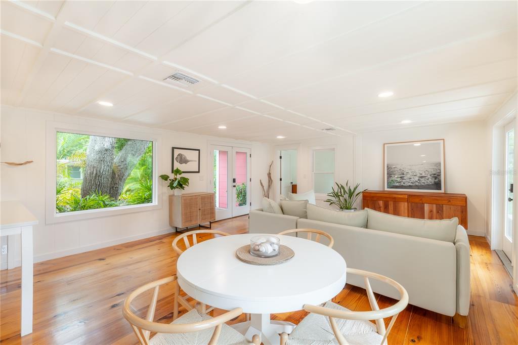 A bright living and dining area with white walls, wood floors, and a large window — 3001 51ST STREET S, GULFPORT, FL