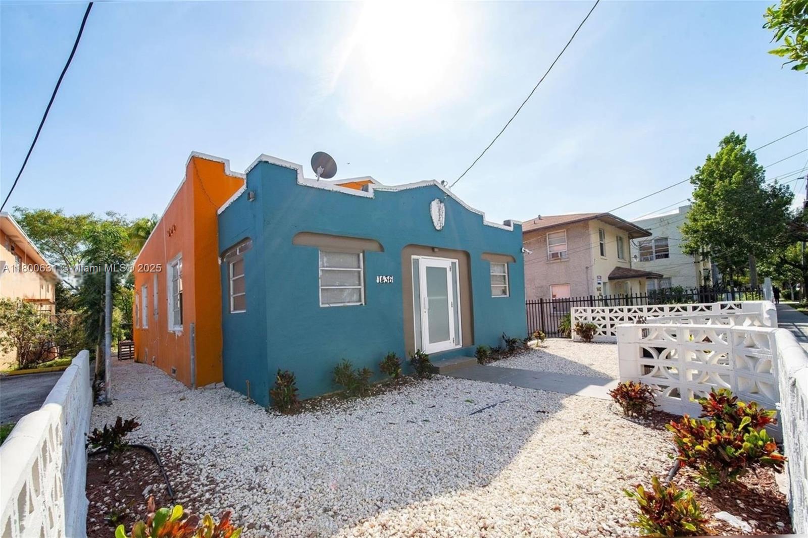 A blue and orange single-story house features a gravel front yard and white decorative fencing — 1436 SW 3rd St, Miami FL 33135, MIAMI, FL
