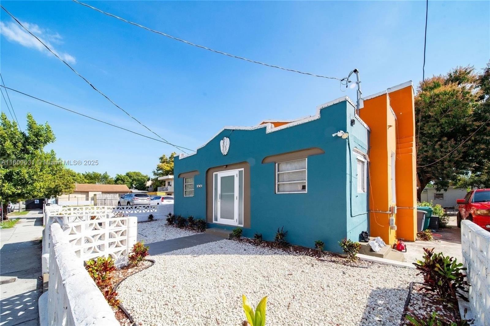 A teal and orange single-story house features a gravel front yard and white masonry fence — 1436 SW 3rd St, Miami FL 33135, MIAMI, FL