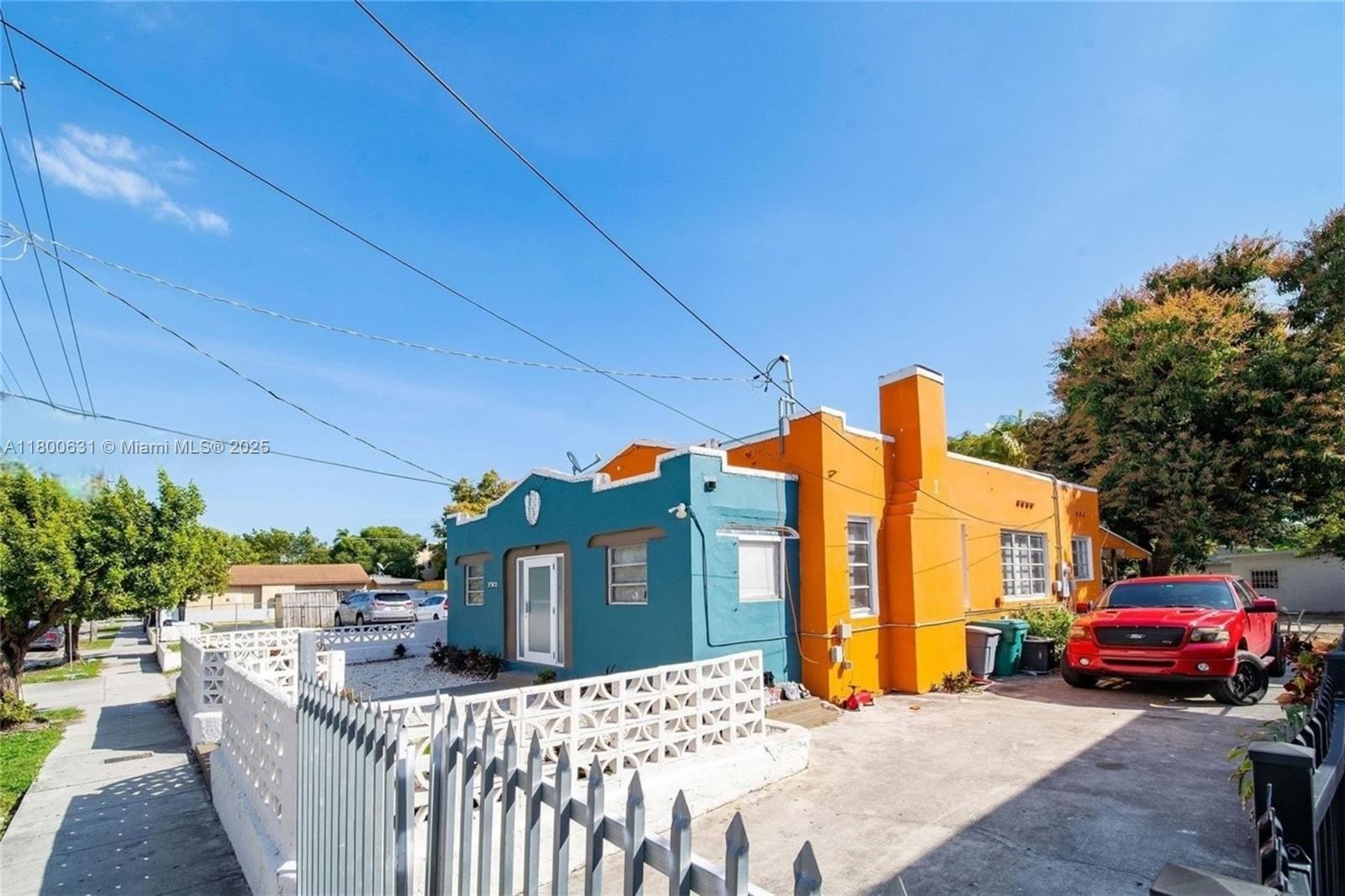 A teal and orange house with a white decorative fence sits under a clear sky — 1436 SW 3rd St, Miami FL 33135, MIAMI, FL