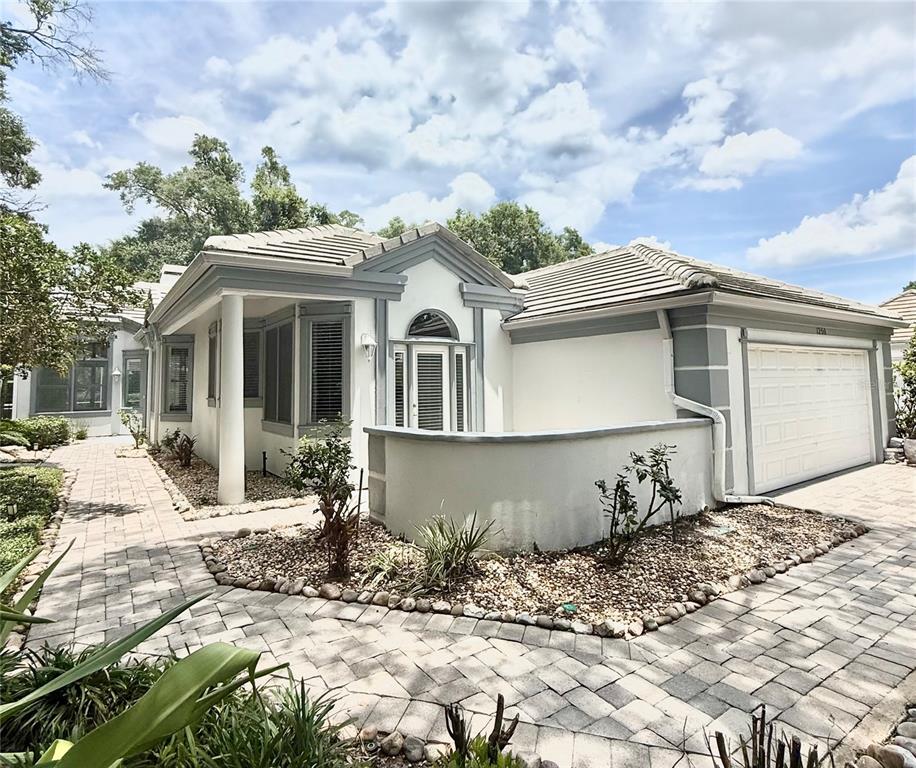 A single-story house with a tiled roof, a paved driveway, and mature trees in front — 1250 E LANGLEY COURT, LAKE MARY, FL