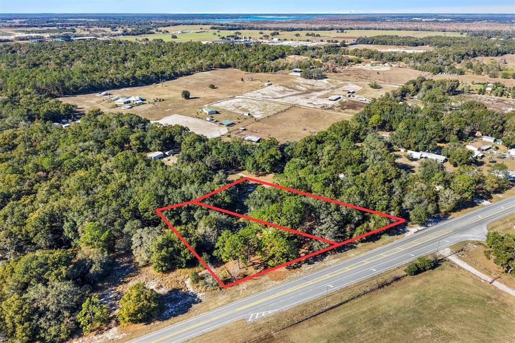 An aerial view shows two adjacent, wooded rectangular lots bordering a paved road — 1582 S US 301, SUMTERVILLE, FL