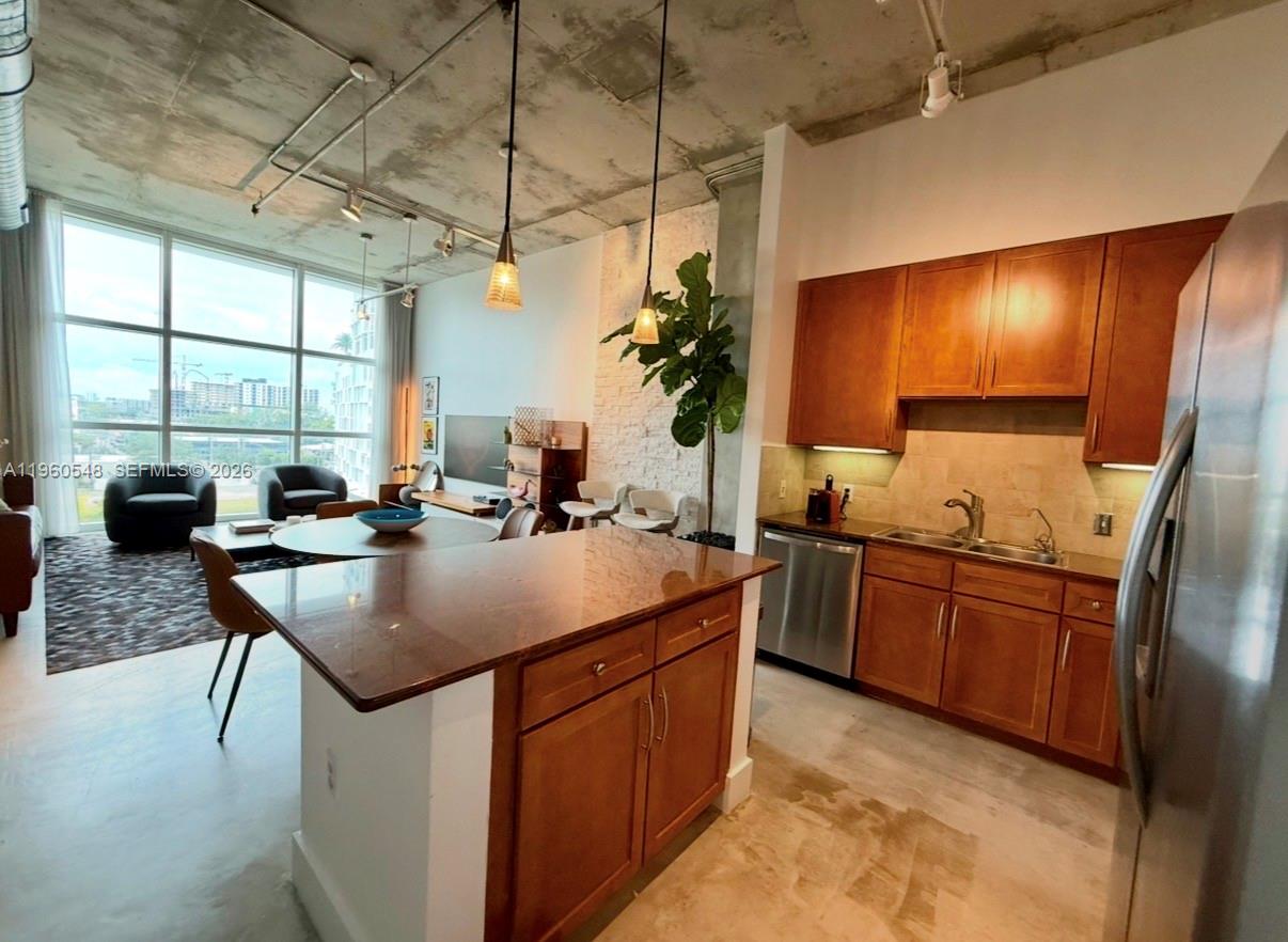 A kitchen with wood cabinets and an island overlooks a living area with floor-to-ceiling windows — 2001 Biscayne Blvd # 3608, Miami FL 33137, MIAMI, FL